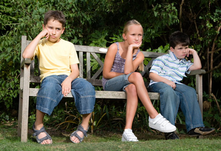 bored children sitting on a bench