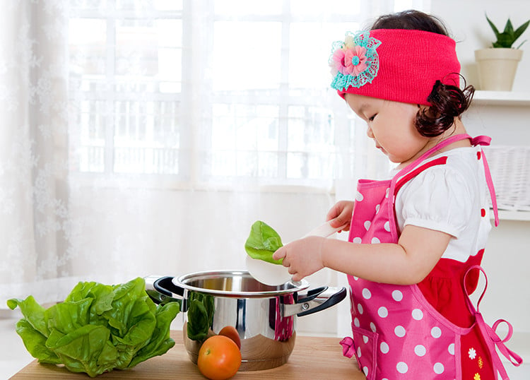 Young child having age-appropriate fun in the kitchen