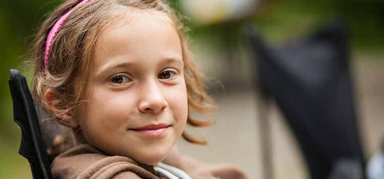 child sitting at a campfire, happily