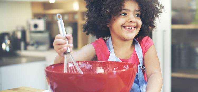 child stirring a red bowl