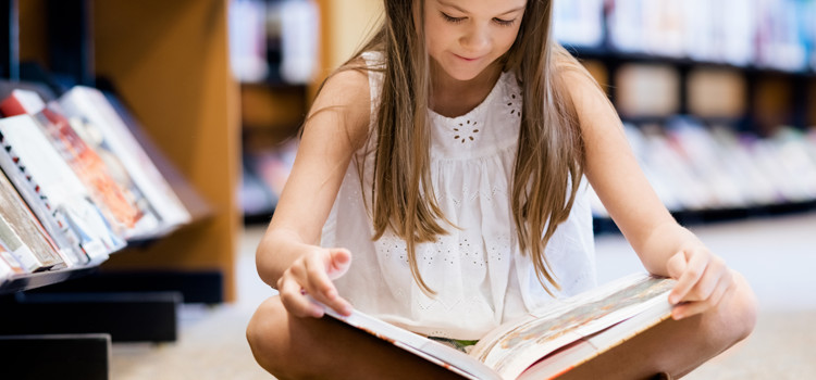 Child reading in library in the summer