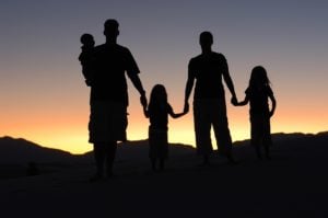 family silhouette standing in sunset
